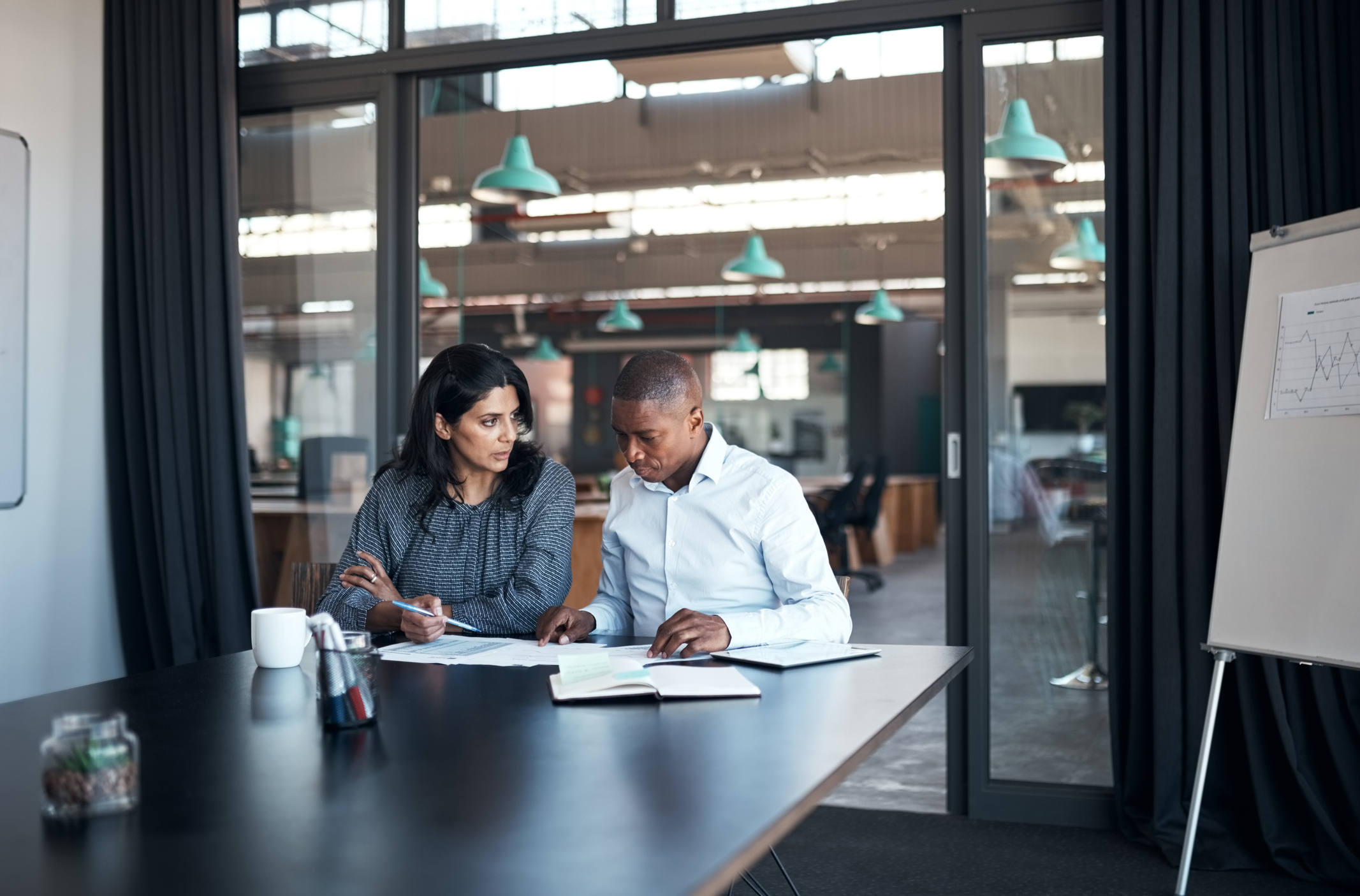 A man and woman in smart clothing discussing an agreement