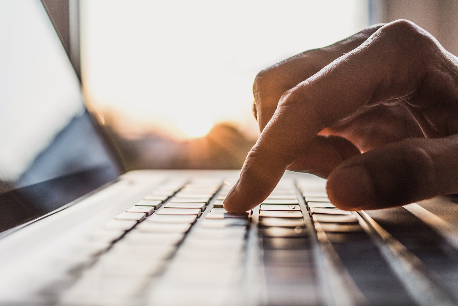 Man's finger clicking a laptop keyboard