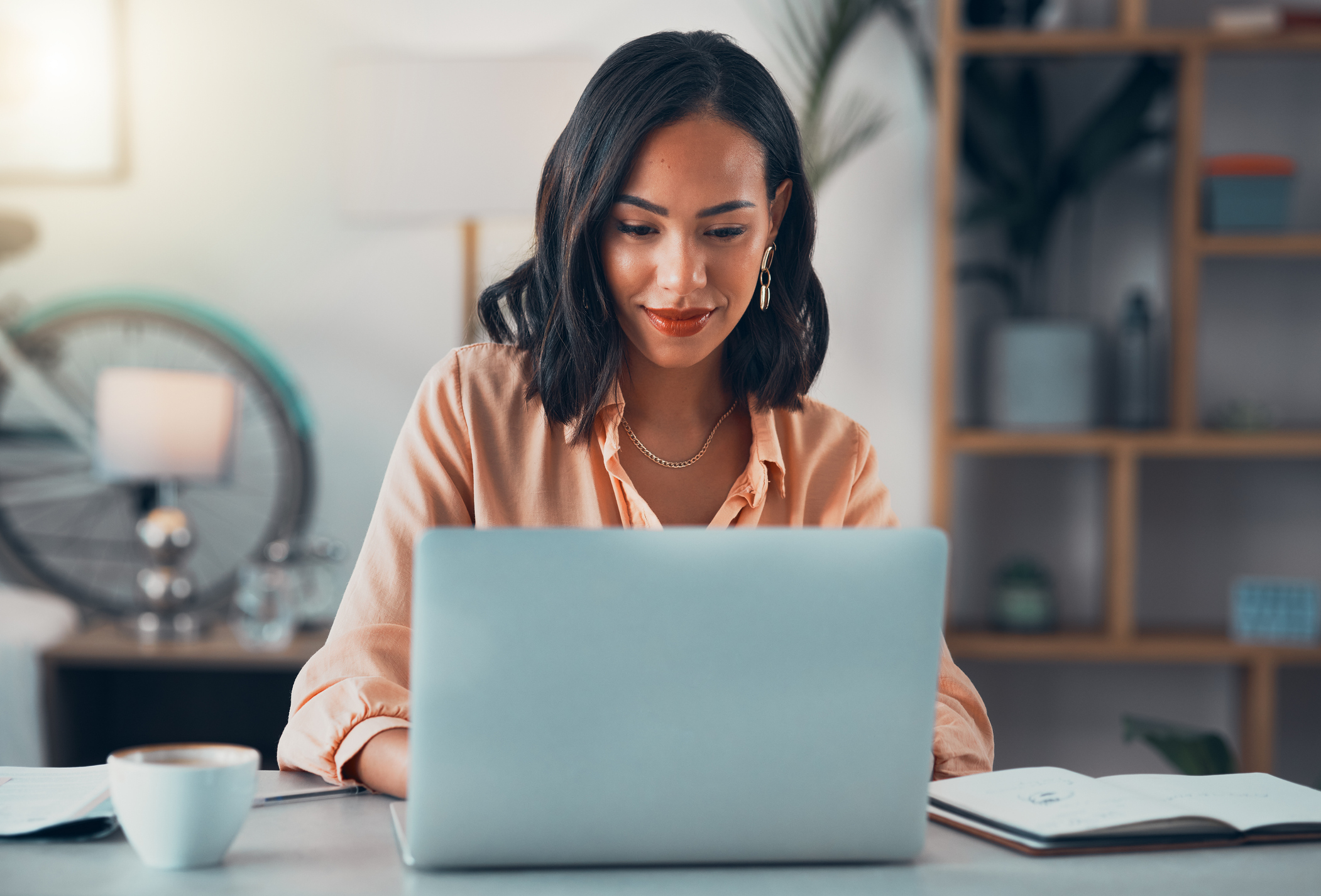 Young woman typing on a laptop while filling out an application