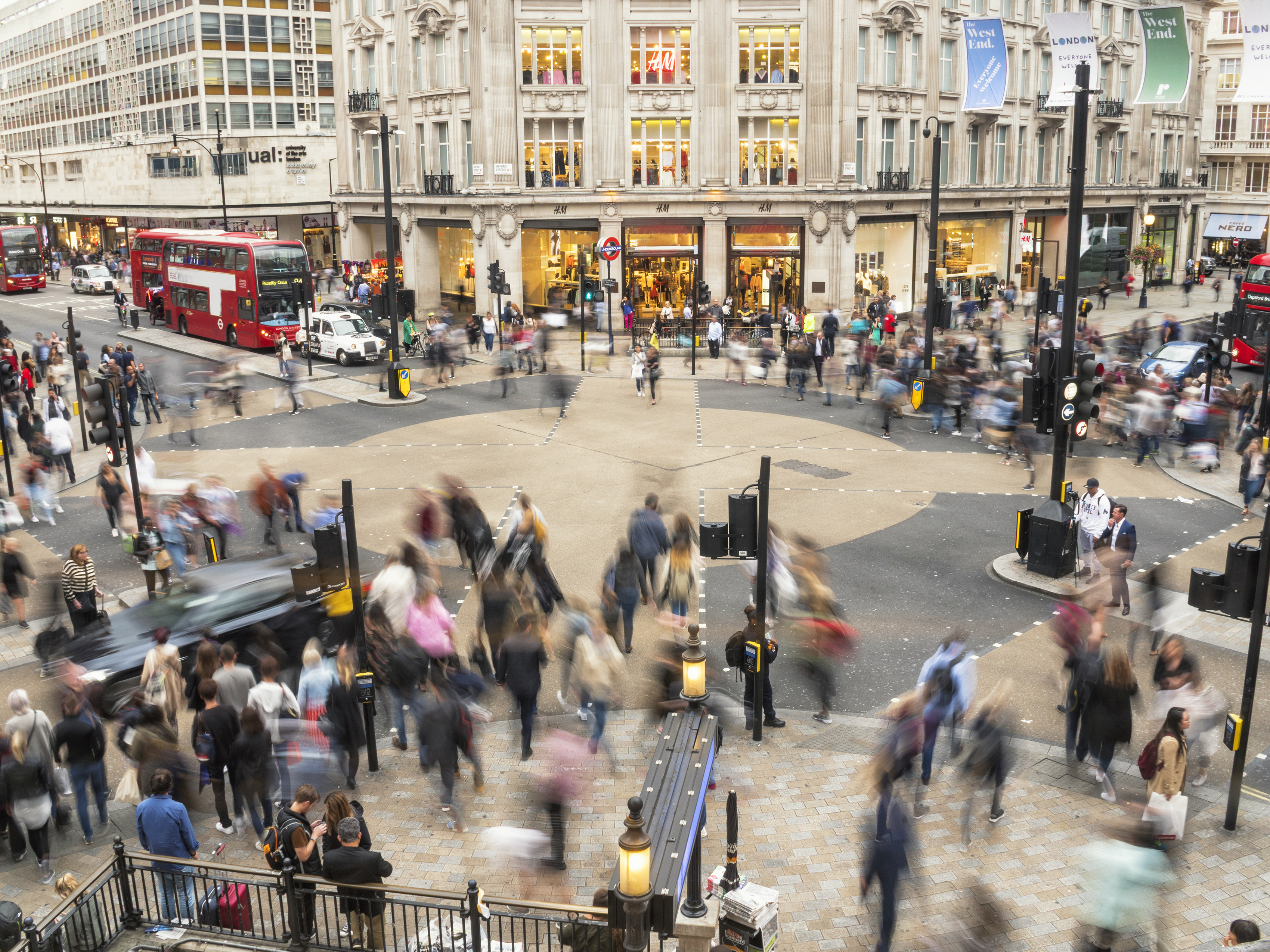 A busy high street in London with dozens of shoppers walking around