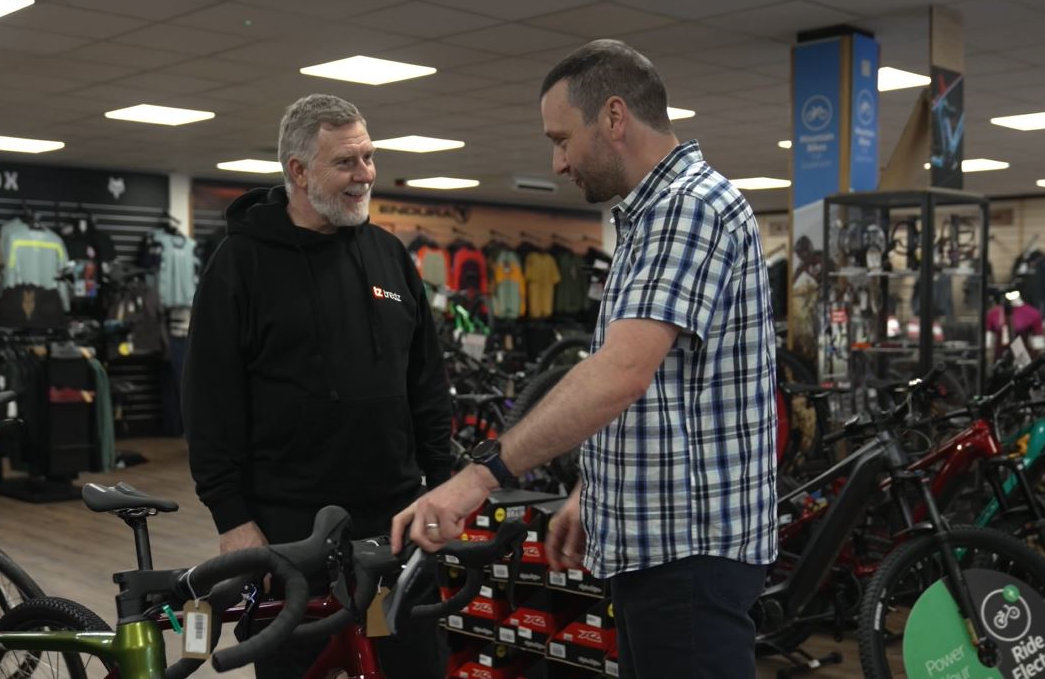 Customer in a cycle shop talking to a bicycle expert about a new bike