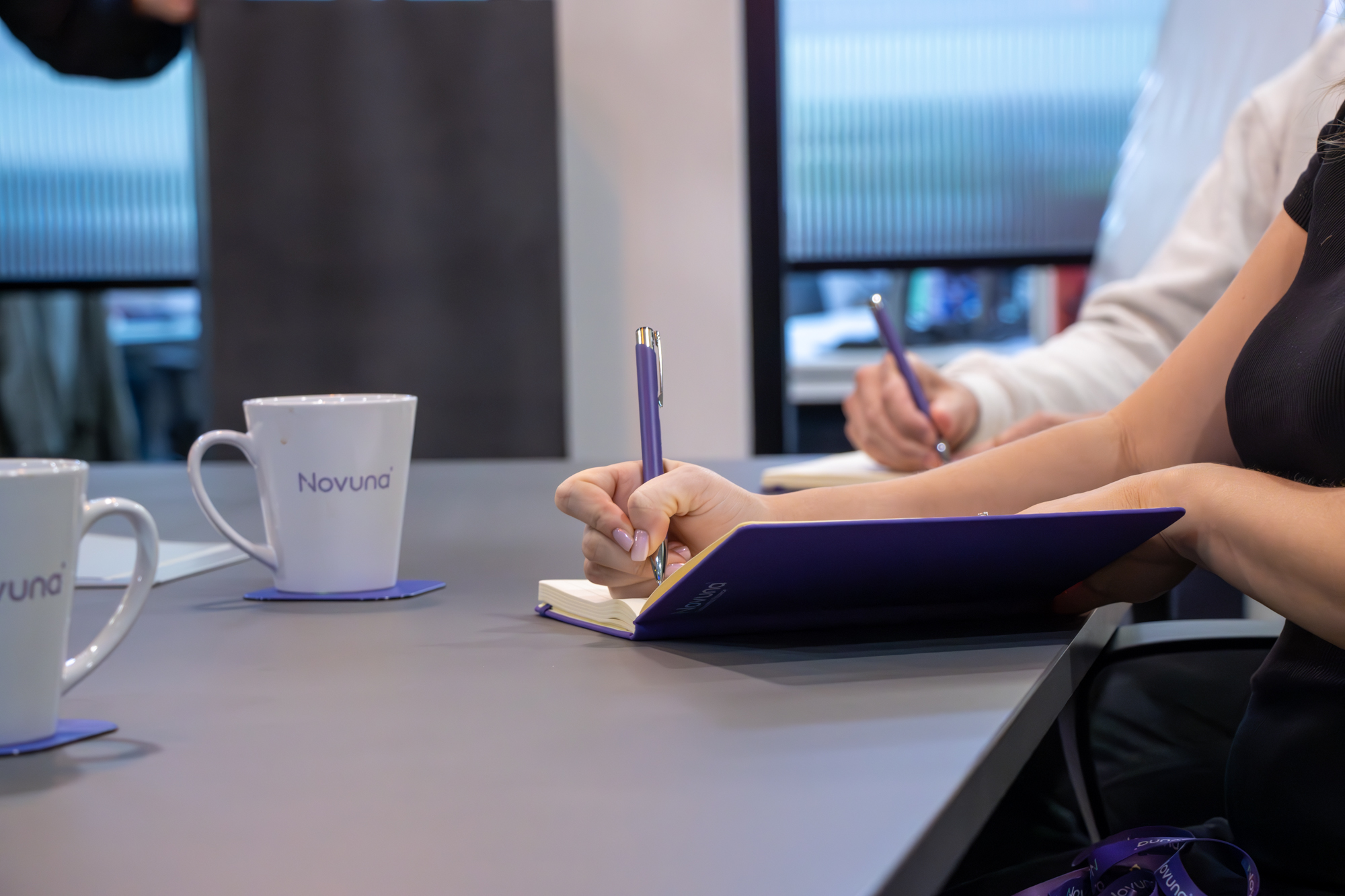Woman writing in a Novuna notebook