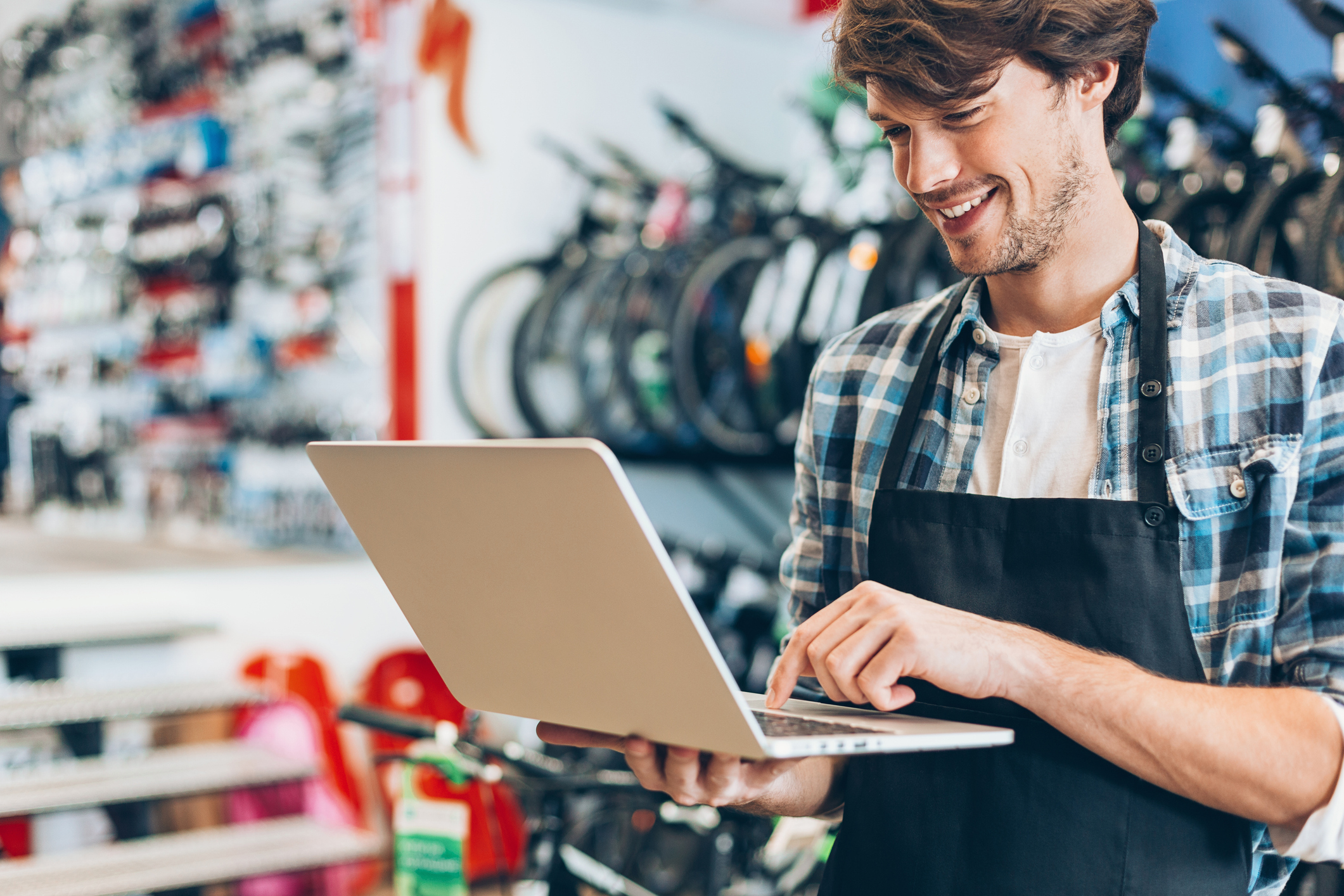 Man working in a bike shop with a laptop